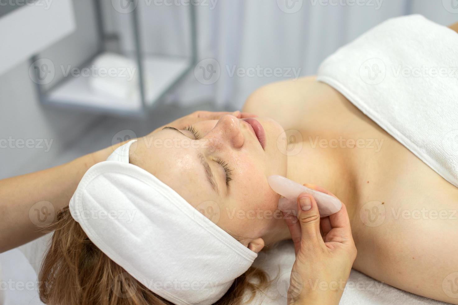 schoonheidsspecialist doet een gelaats massage met een reeks van gouache foto