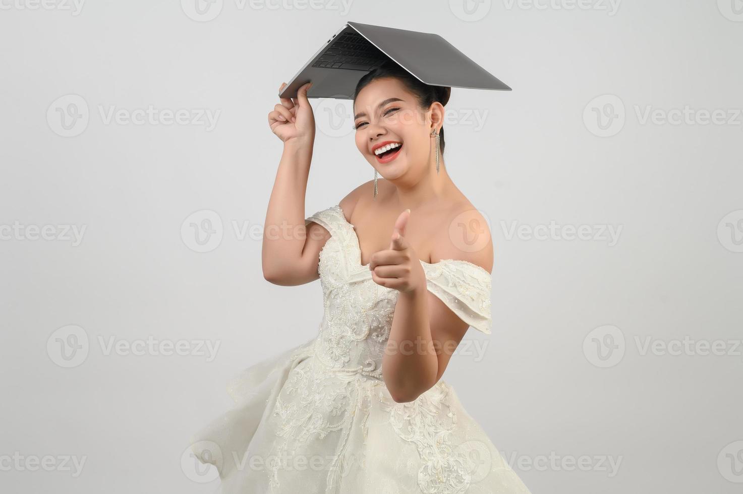 jong Aziatisch mooi bruid houding met laptop computer in hand- foto