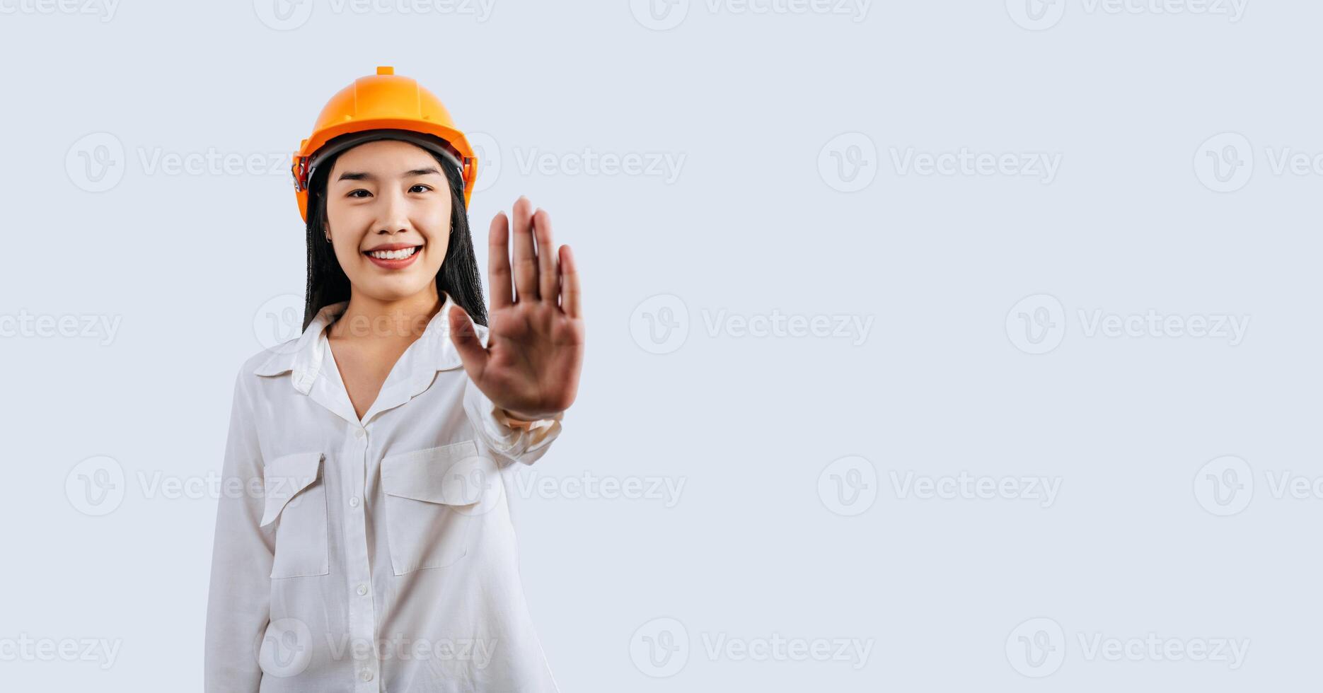 vrouw ingenieur met harde hoed en Open hand- aan het doen hou op teken houding foto