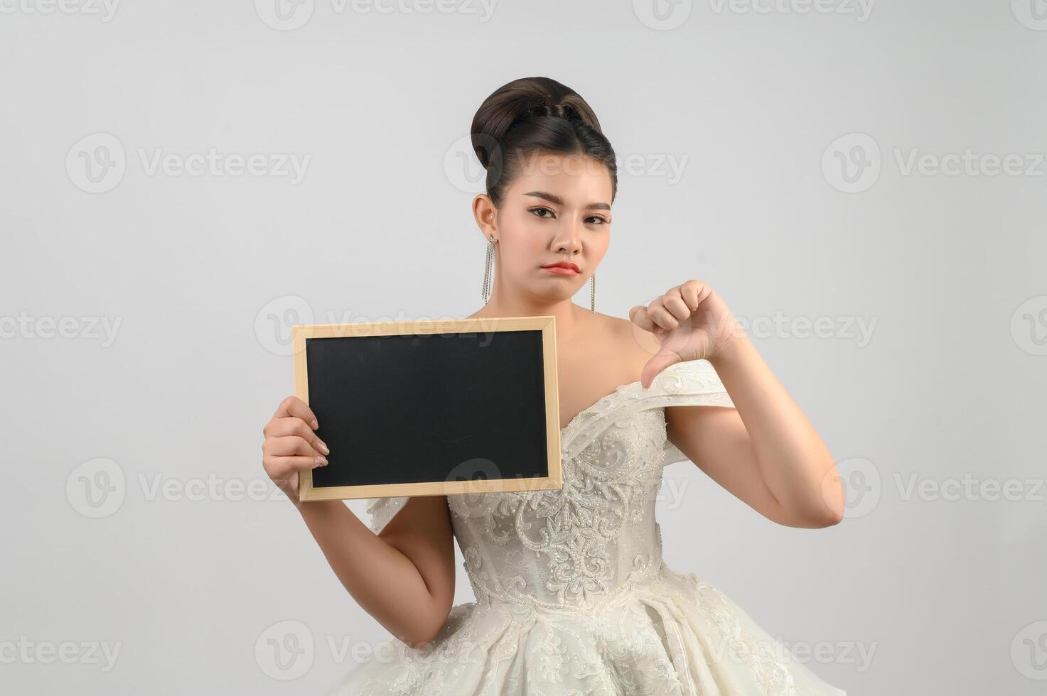 jong Aziatisch mooi bruid houding met blanco schoolbord in hand- foto