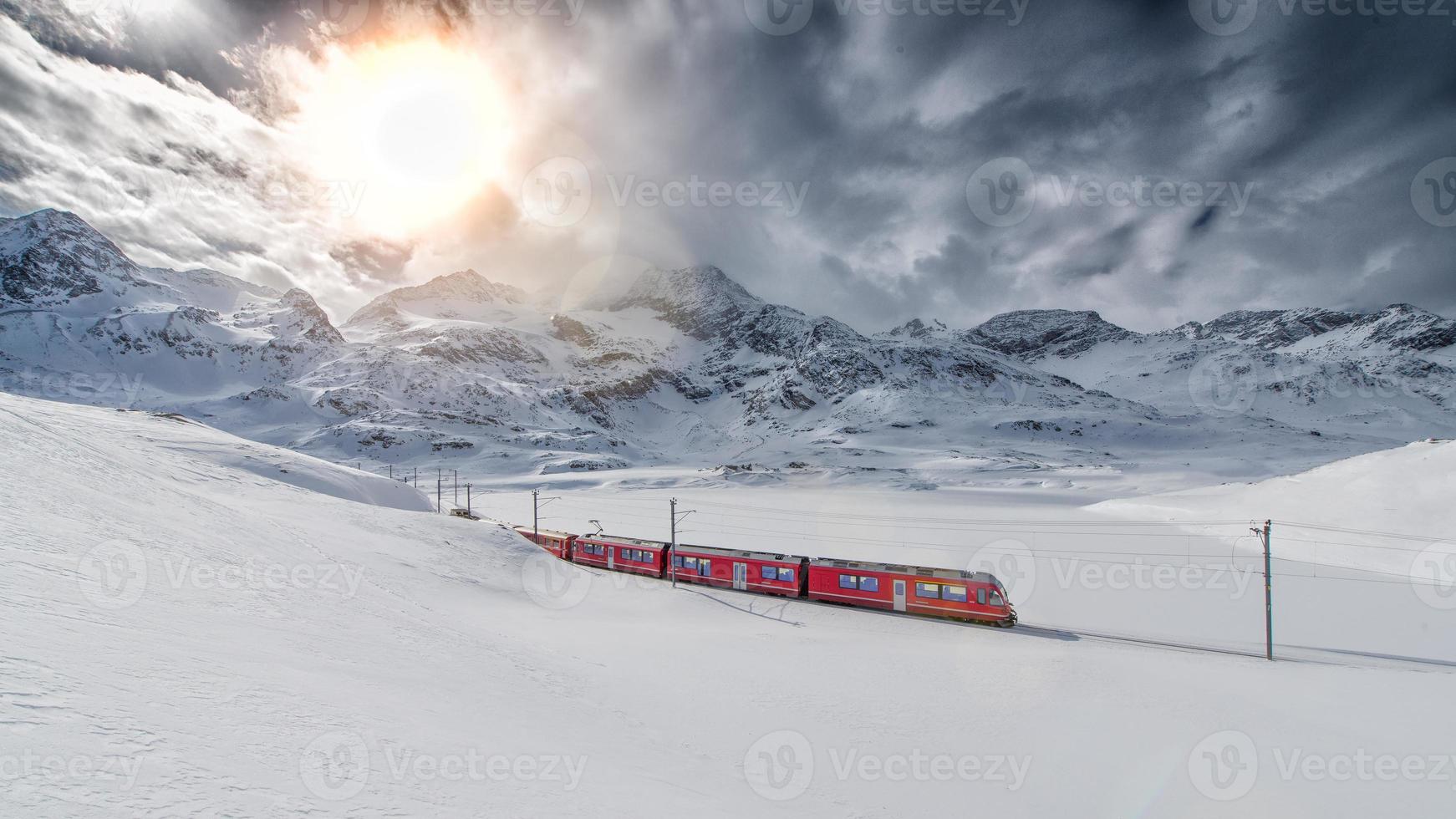 Zwitserse bergtrein Bernina Express doorkruist door de hoge bergsneeuw foto