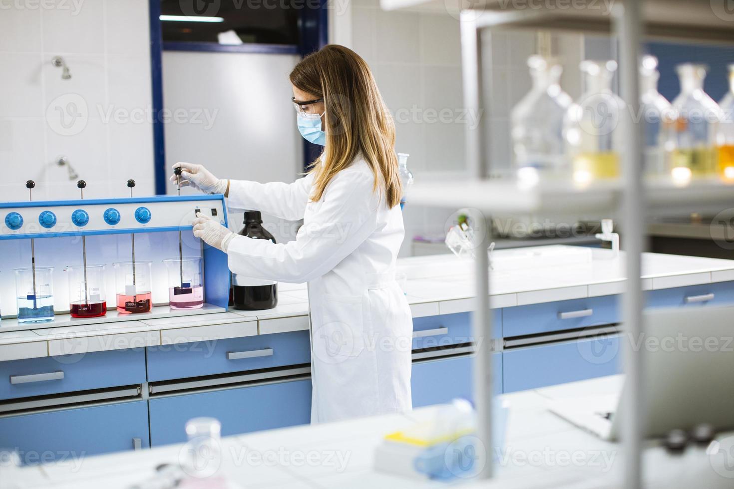 jonge onderzoeker analyseren van chemische gegevens in de flocculator in laboratorium foto