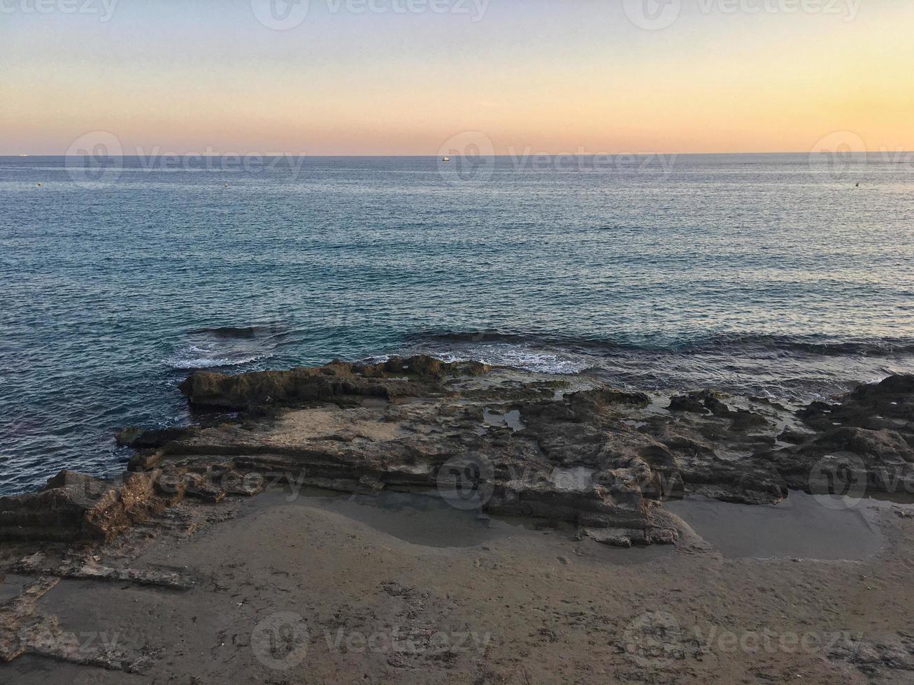 mediterraan strand zonder mensen bij zonsondergang in calpe, alicante foto