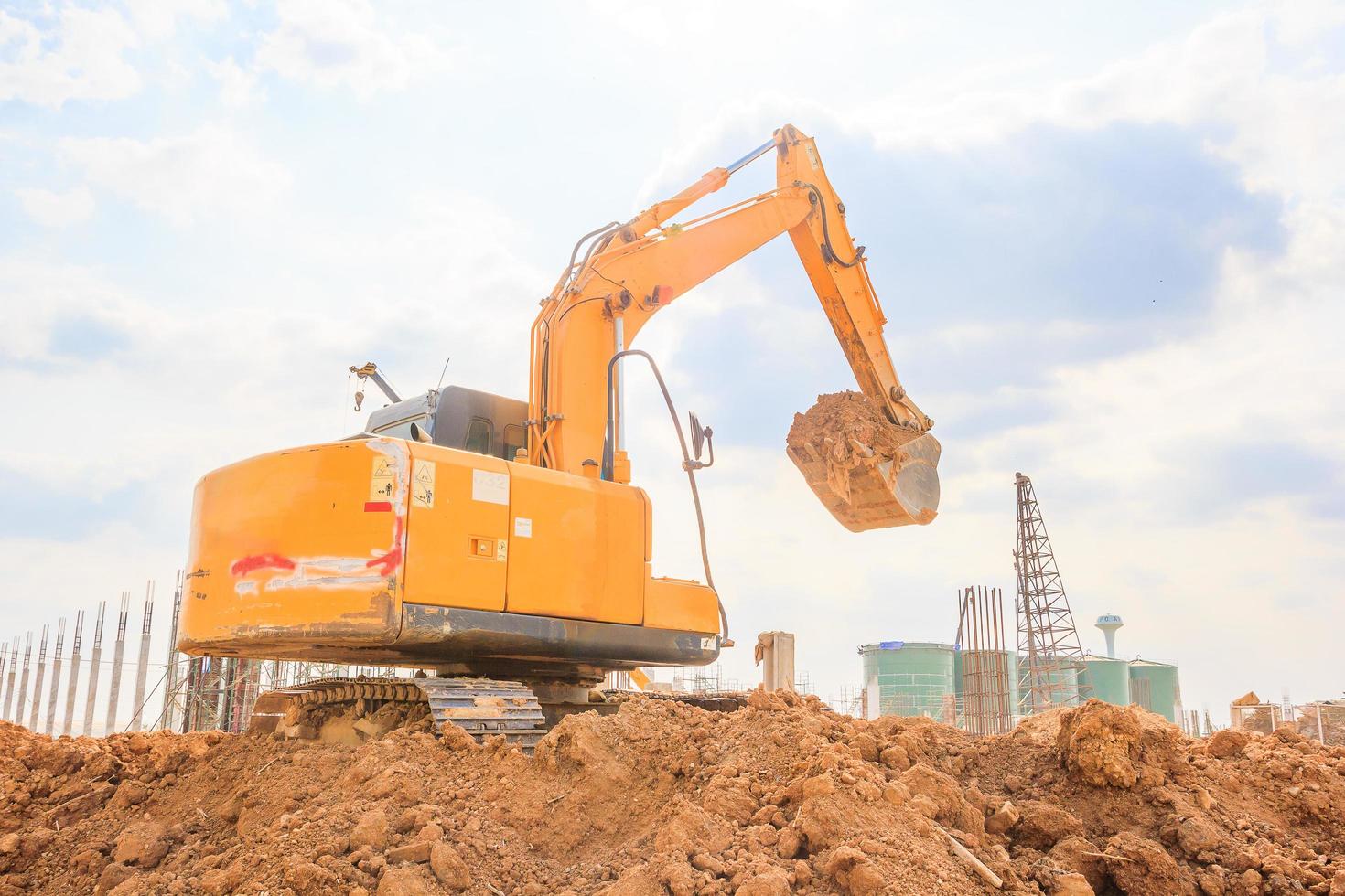 graafmachine-machine op een bouwplaats tegen blauwe hemelachtergrond foto