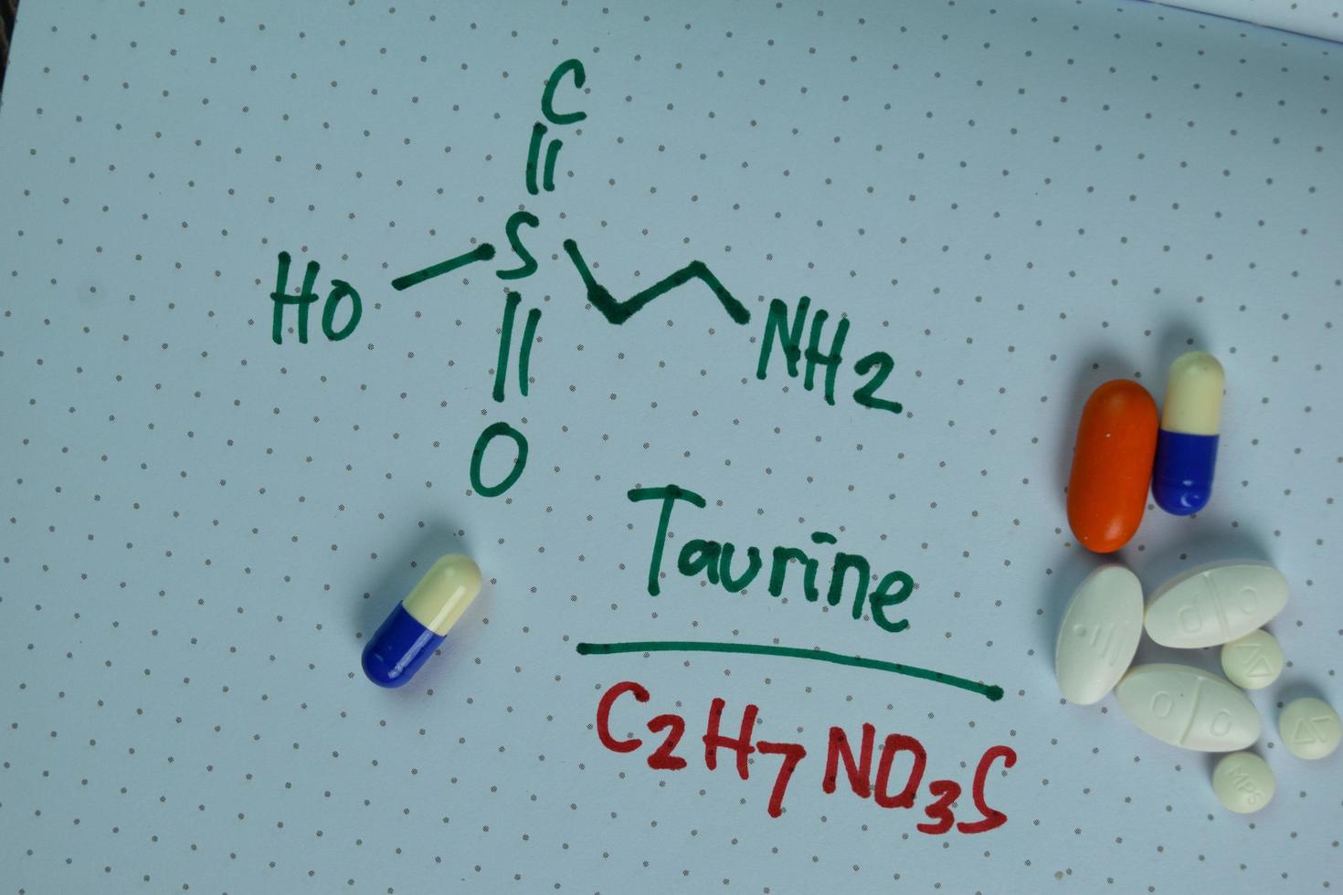 structurele chemische formule geschreven op een boek met pillen die chemicaliën vertegenwoordigen foto