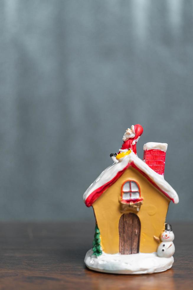miniatuur kerstman zittend op een dak, kerstlegende en prettige vakantie concept foto