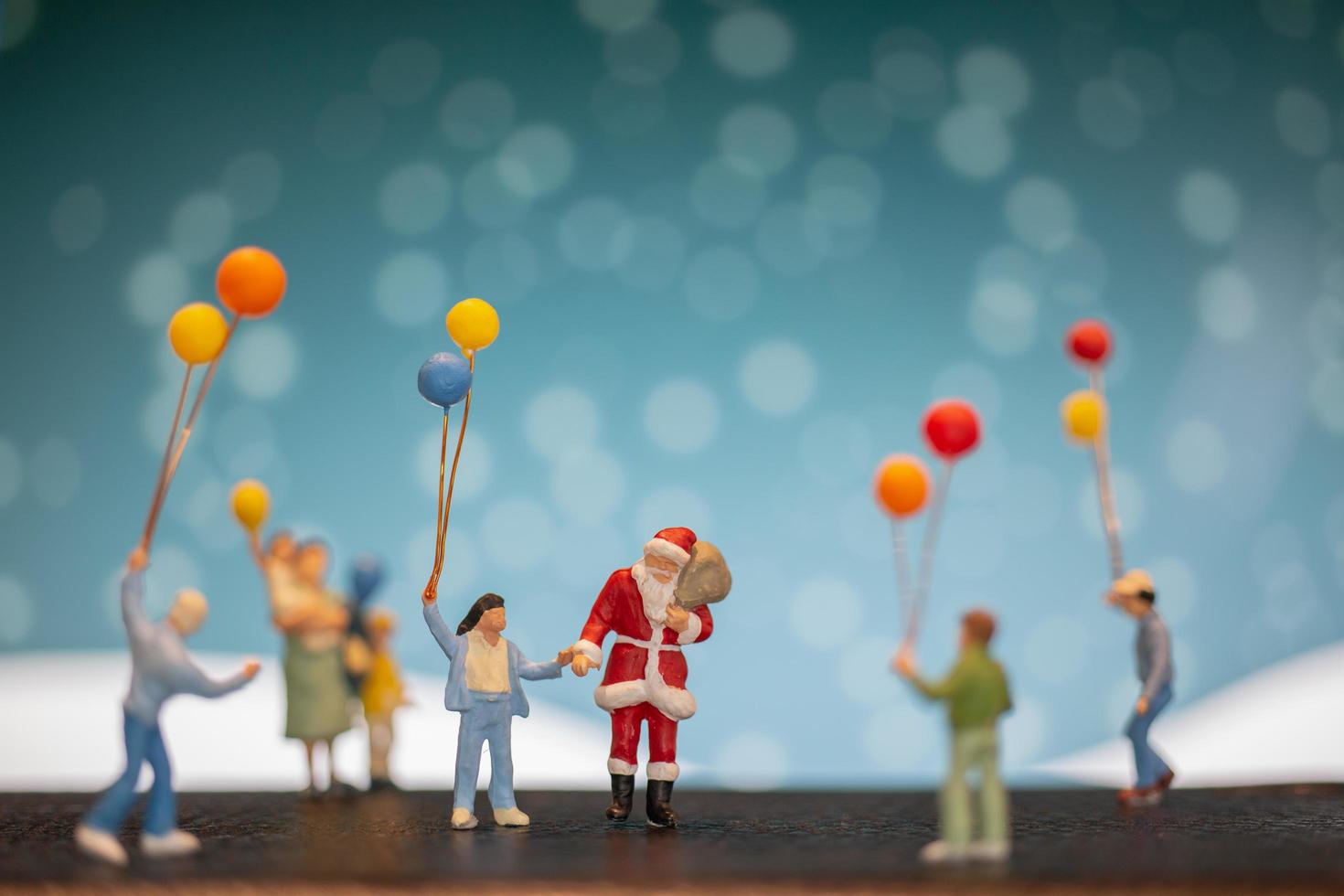 miniatuur kerstman en kinderen met ballonnen, prettige kerstdagen en gelukkig nieuwjaar concept foto