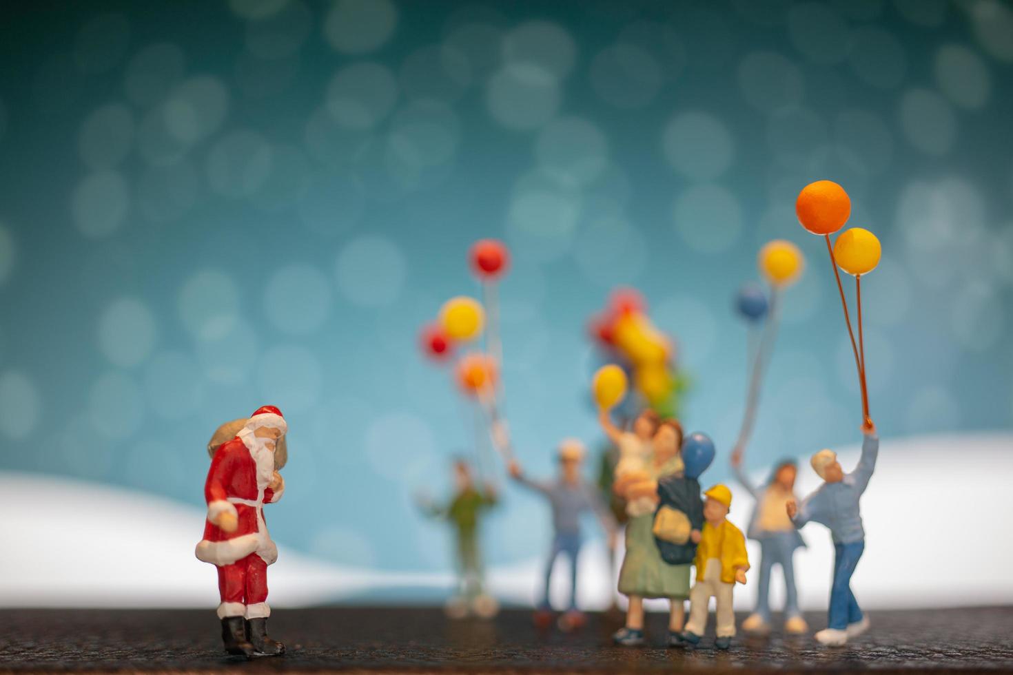 miniatuur kerstman en kinderen met ballonnen, prettige kerstdagen en gelukkig nieuwjaar concept foto