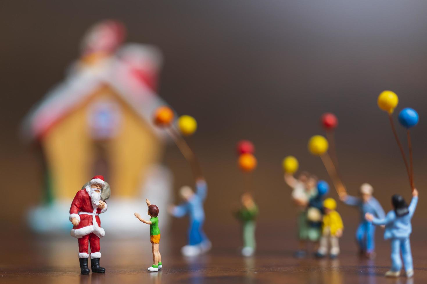 miniatuur kerstman en kinderen met ballonnen, prettige kerstdagen en gelukkig nieuwjaar concept foto