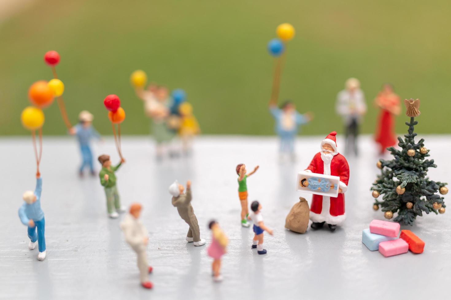 miniatuur kerstman met geschenken voor een gelukkig gezin, kerstmis en een gelukkig nieuwjaar concept foto