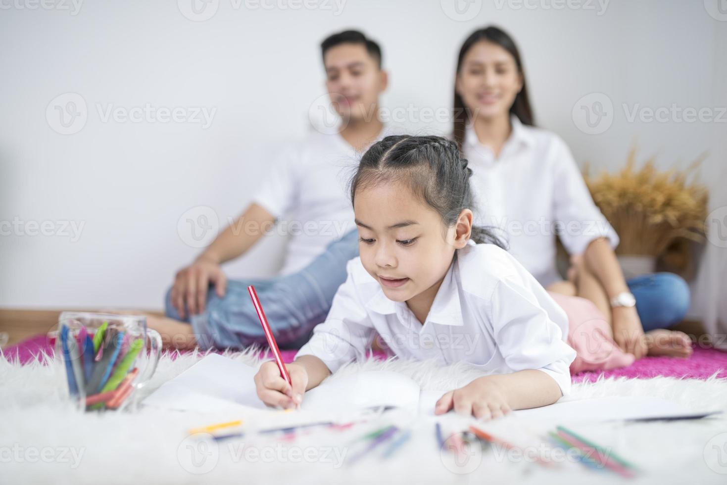 dochter kleuren met ouders op de achtergrond foto