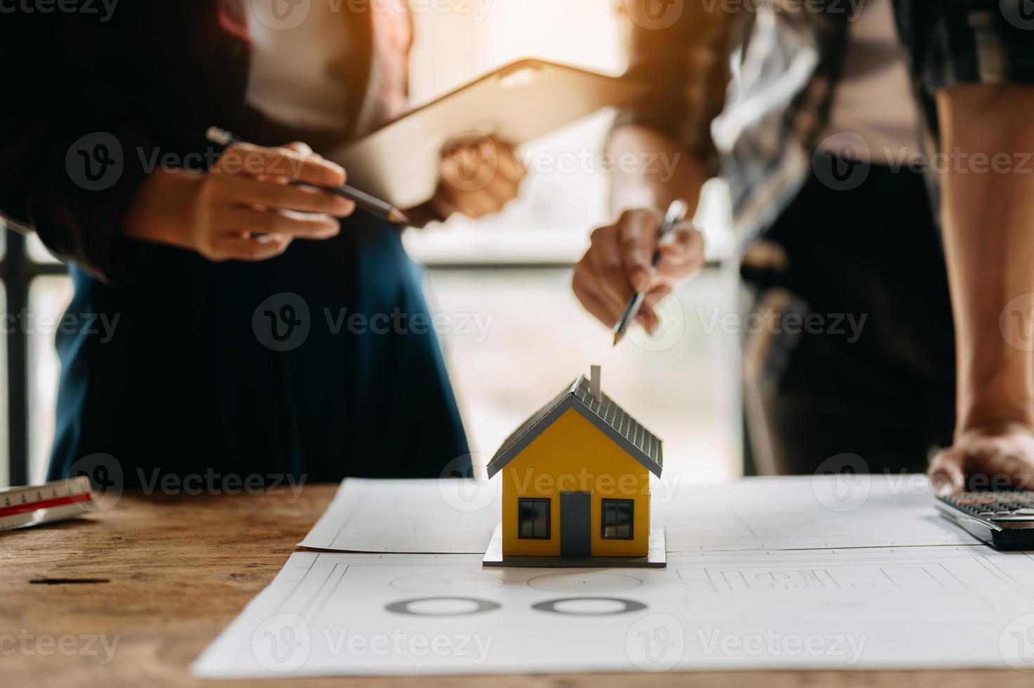 twee collega's bespreken gegevens werken en tablet, laptop met op architectonisch project op bouwplaats aan balie in kantoor foto