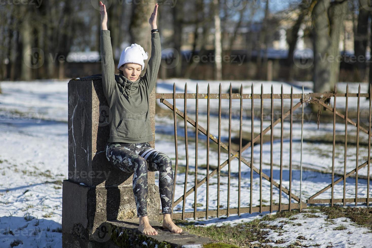 een jonge atletische vrouw voert buiten yoga- en meditatieoefeningen uit foto