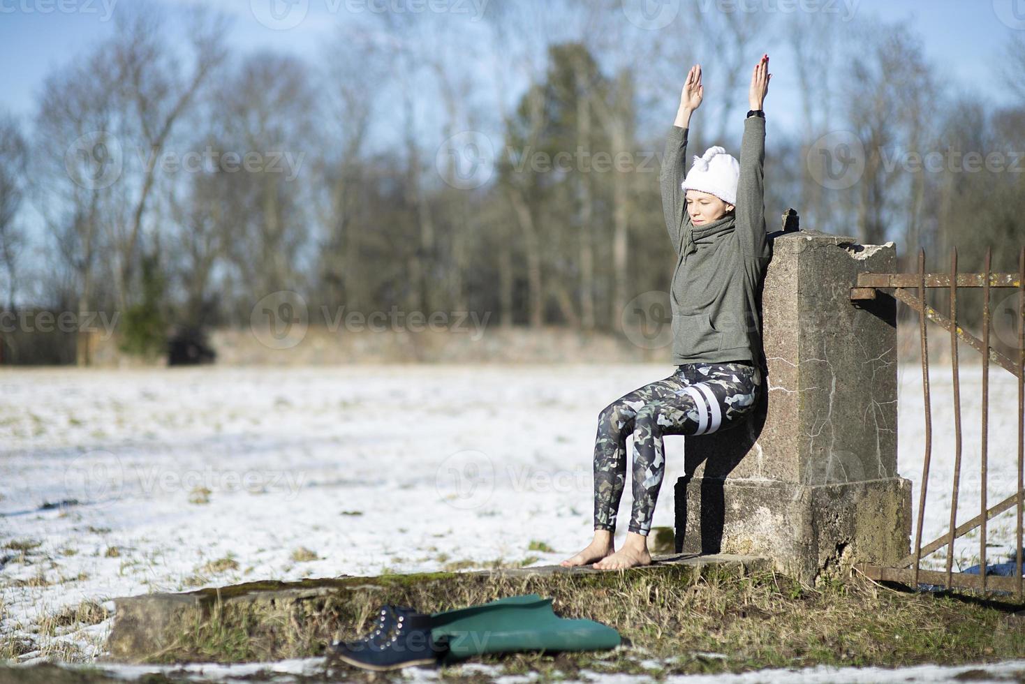 een jonge atletische vrouw voert buiten yoga- en meditatieoefeningen uit foto