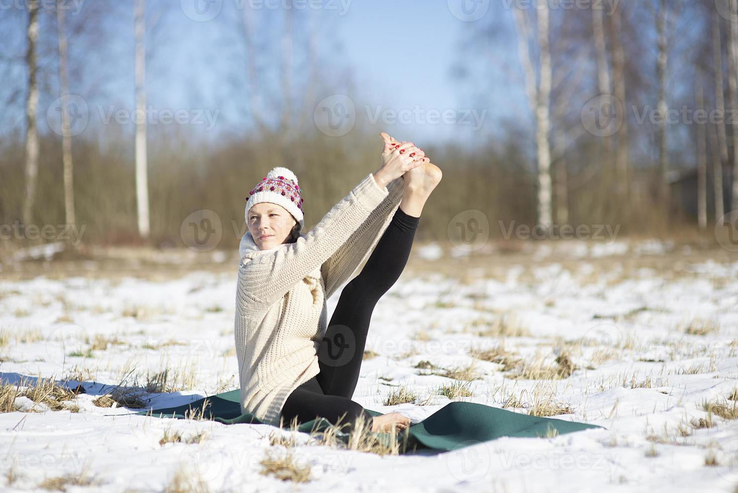 een jonge atletische vrouw voert buiten yoga- en meditatieoefeningen uit foto