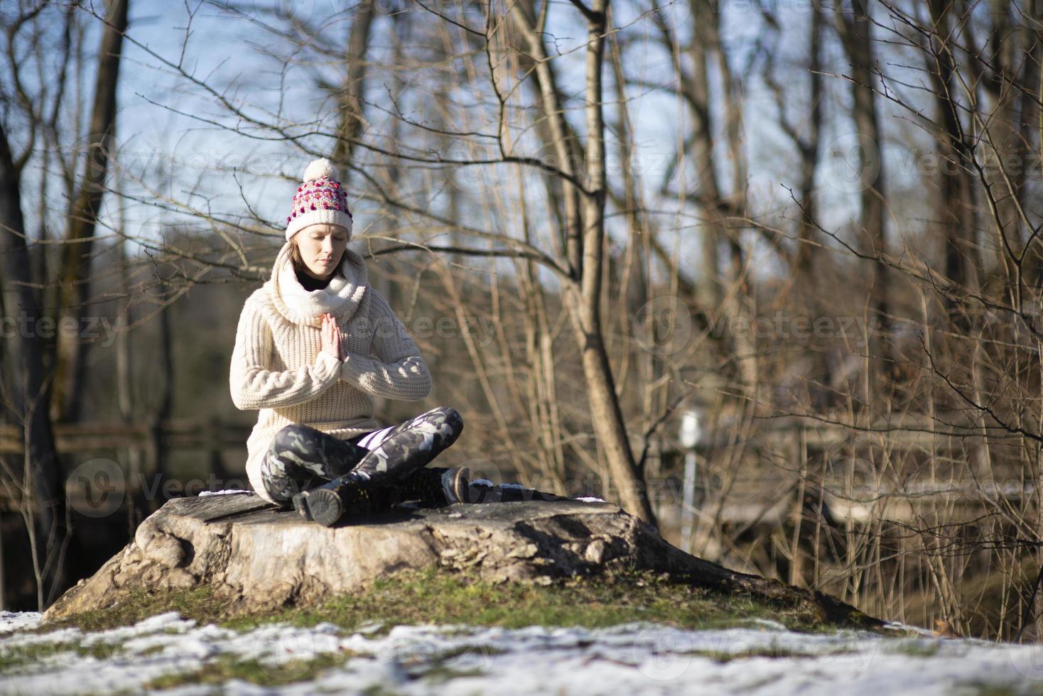 een jonge atletische vrouw voert buiten yoga- en meditatieoefeningen uit foto