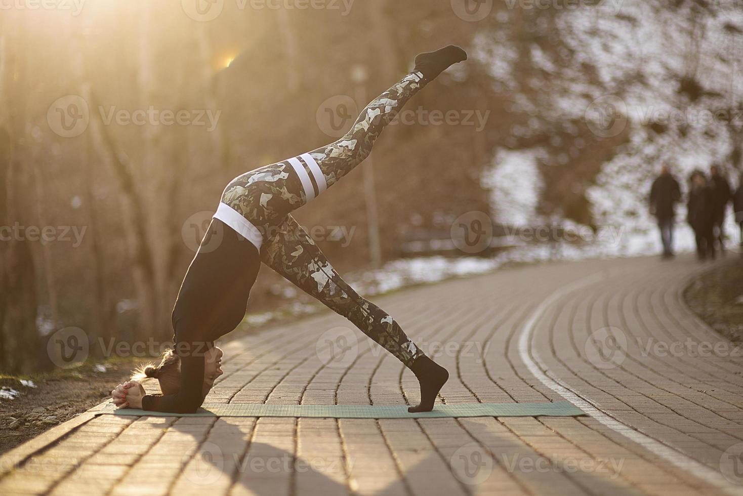 een jonge atletische vrouw voert buiten yoga- en meditatieoefeningen uit foto