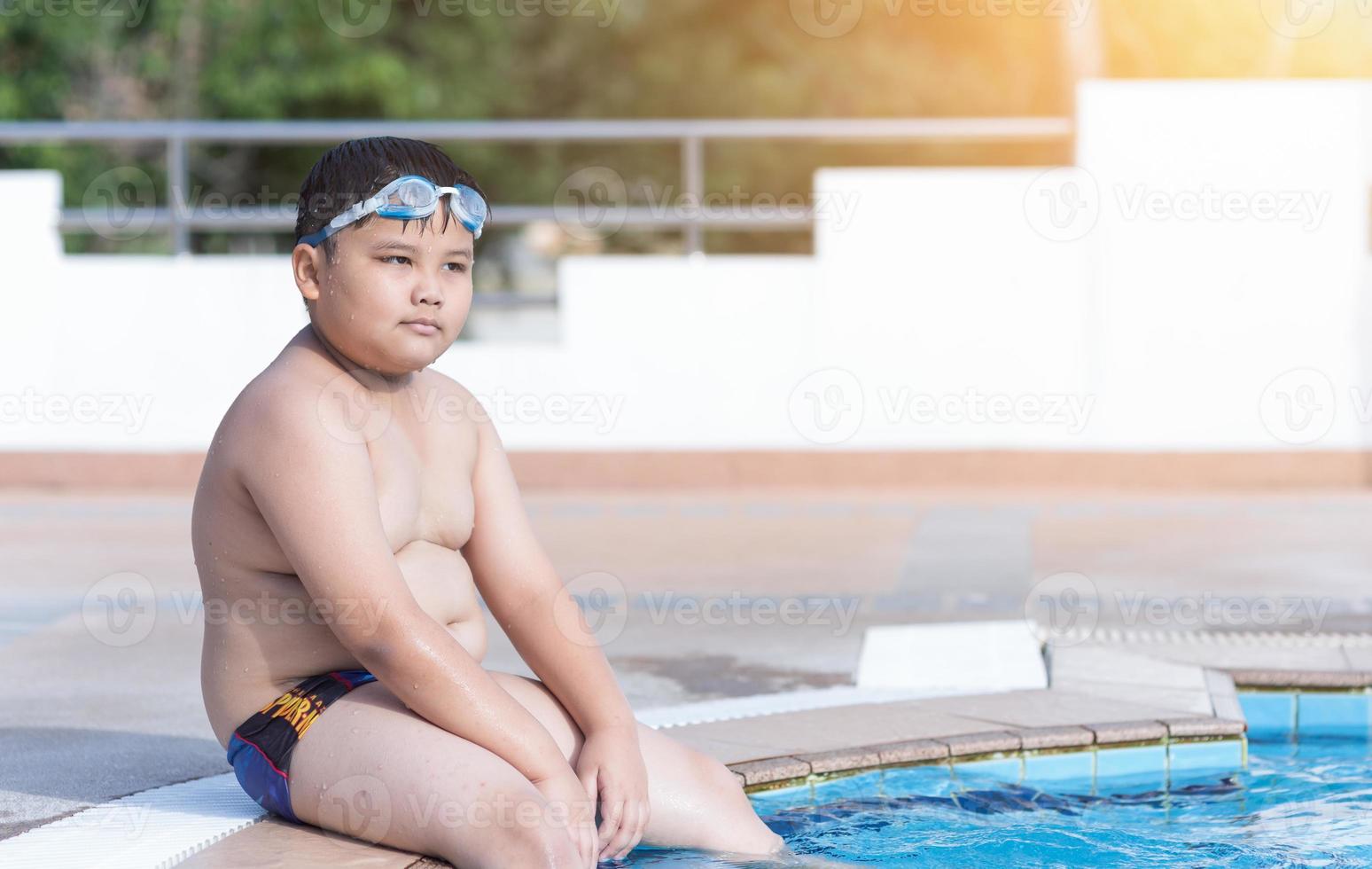 zwaarlijvig dik jongen in zwemmen zwembad foto