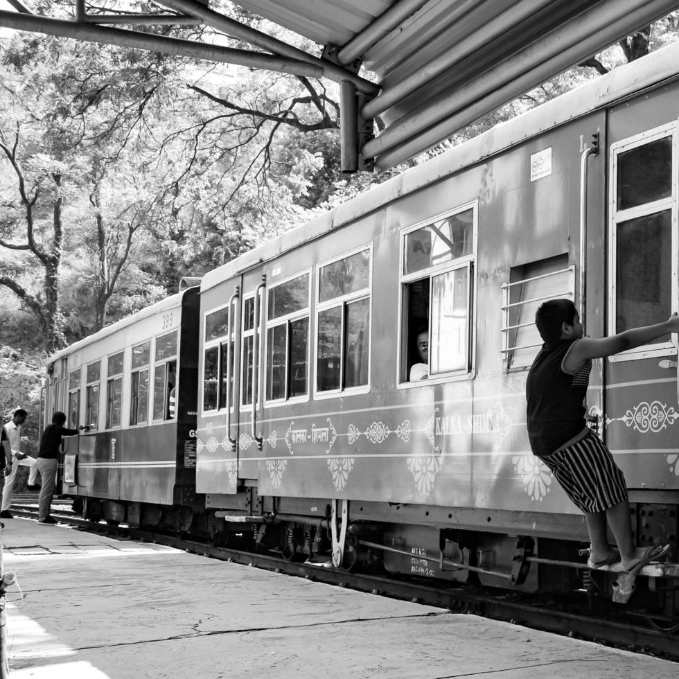 shimla, himachal pradesh, india - 14 mei 2022 - speelgoedtrein kalka-shimla route, bewegend op de spoorlijn naar de heuvel, speelgoedtrein van kalka naar shimla in india tussen groen natuurlijk bos foto