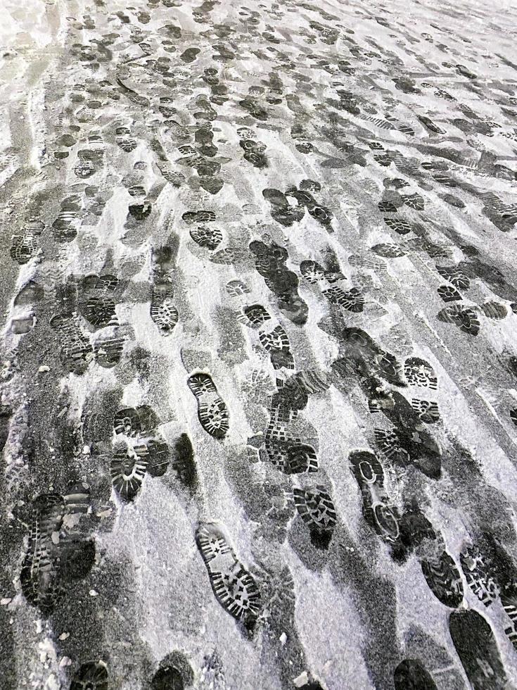 sporen van mensen in de sneeuw, verticaal foto. foto