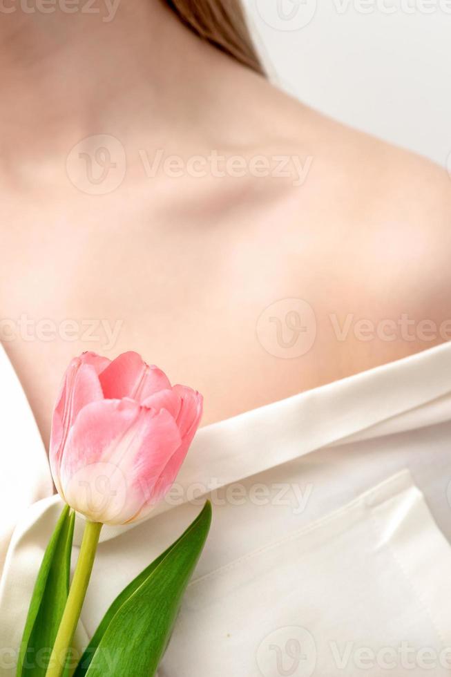 een roze tulp tegen jong vrouw foto