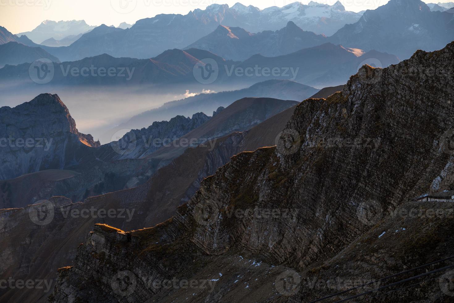 verkoudheid blauwachtig berg landschap in mist Bij zonsopkomst foto