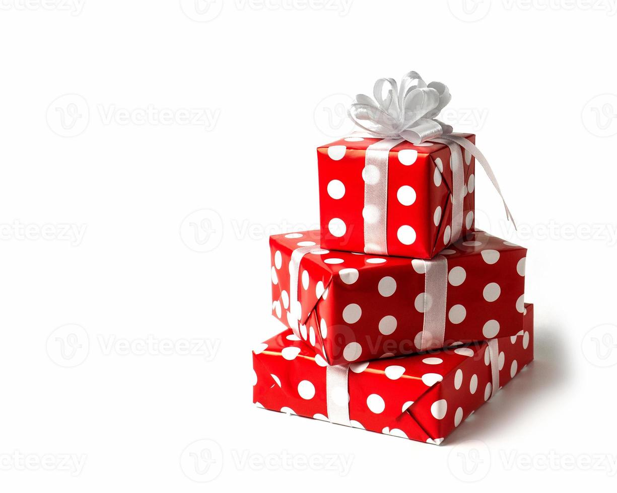 verrassing geschenk. een rood doos met wit polka stippen, met een wit boog Aan de achtergrond. isoleren foto
