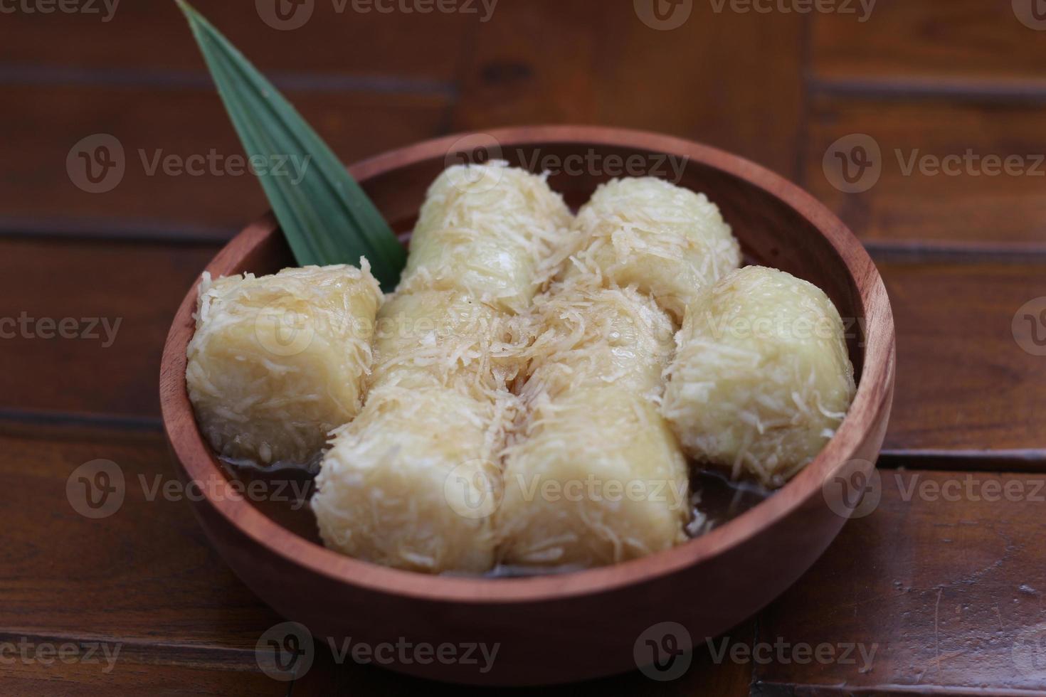 een dichtbij omhoog van lupis met geraspt kokosnoot en bruin suiker saus geserveerd in een houten schaal. Indonesisch traditioneel voedsel foto concept.