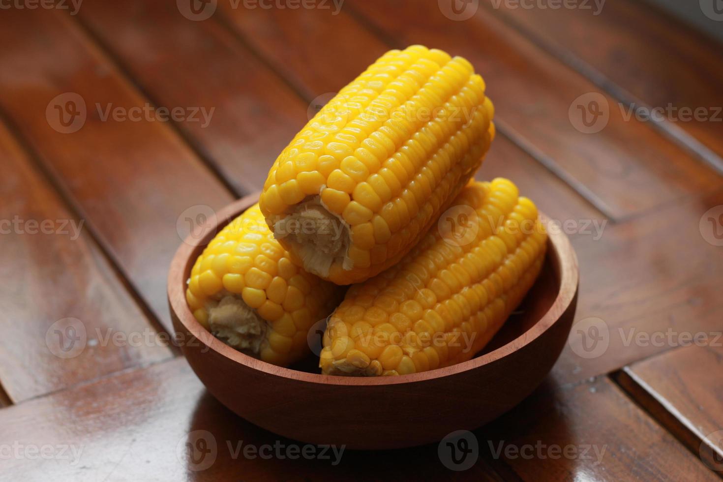 een dichtbij omhoog van maïs Aan de maïskolf geserveerd in een houten schaal. foto