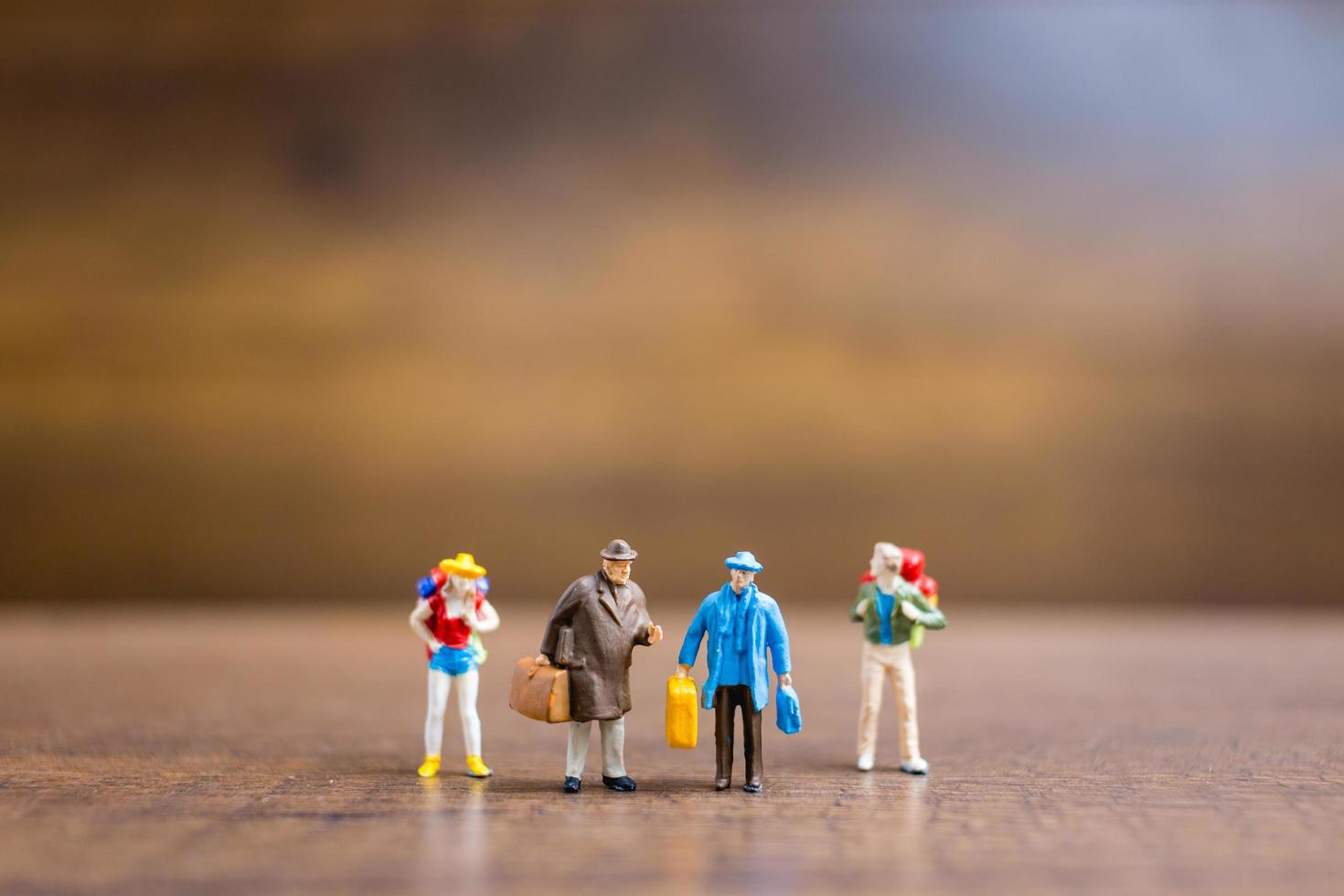 miniatuurreizigers die zich op een houten achtergrond, reisconcept bevinden foto