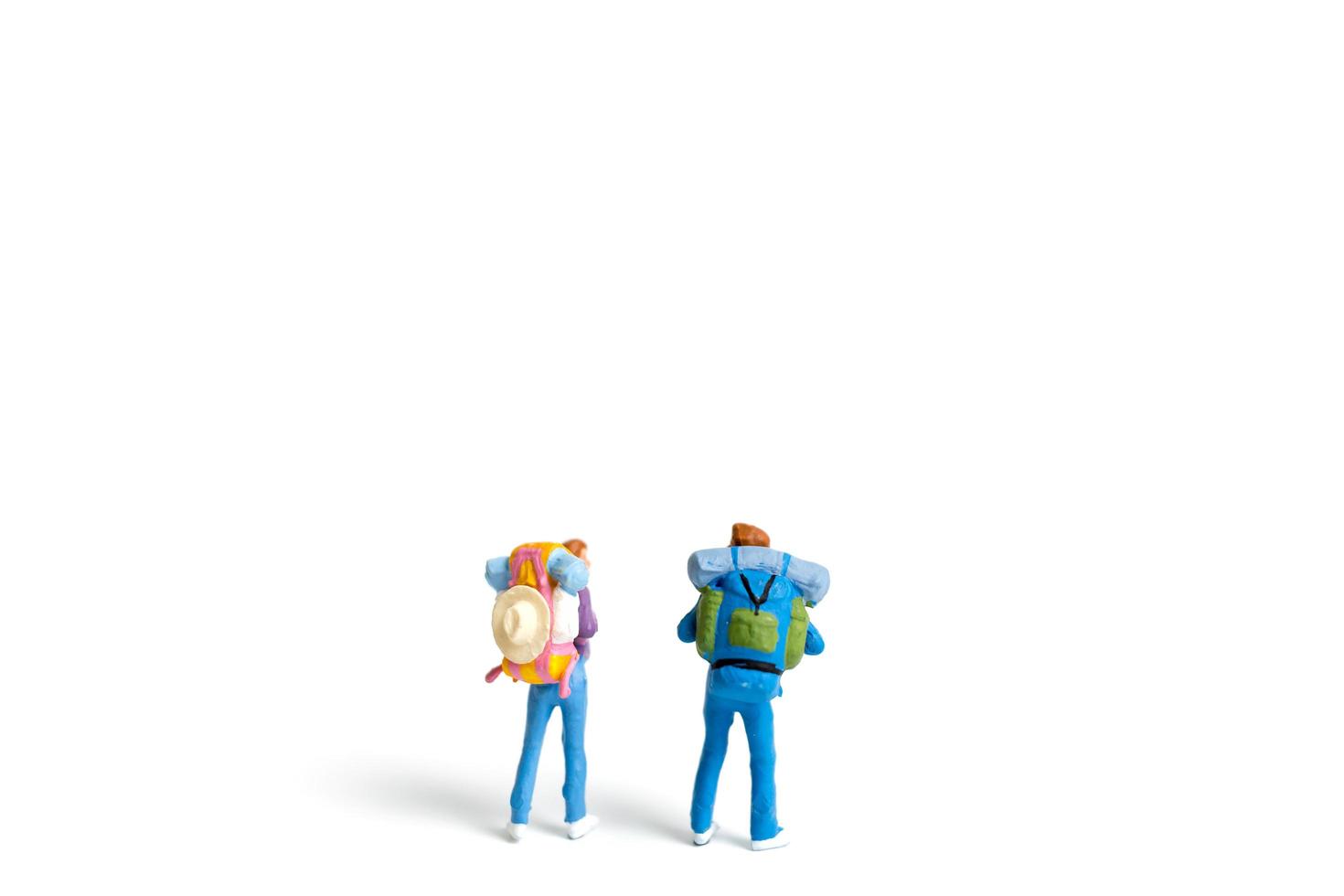 miniatuur backpacker toerist geïsoleerd op een witte achtergrond foto