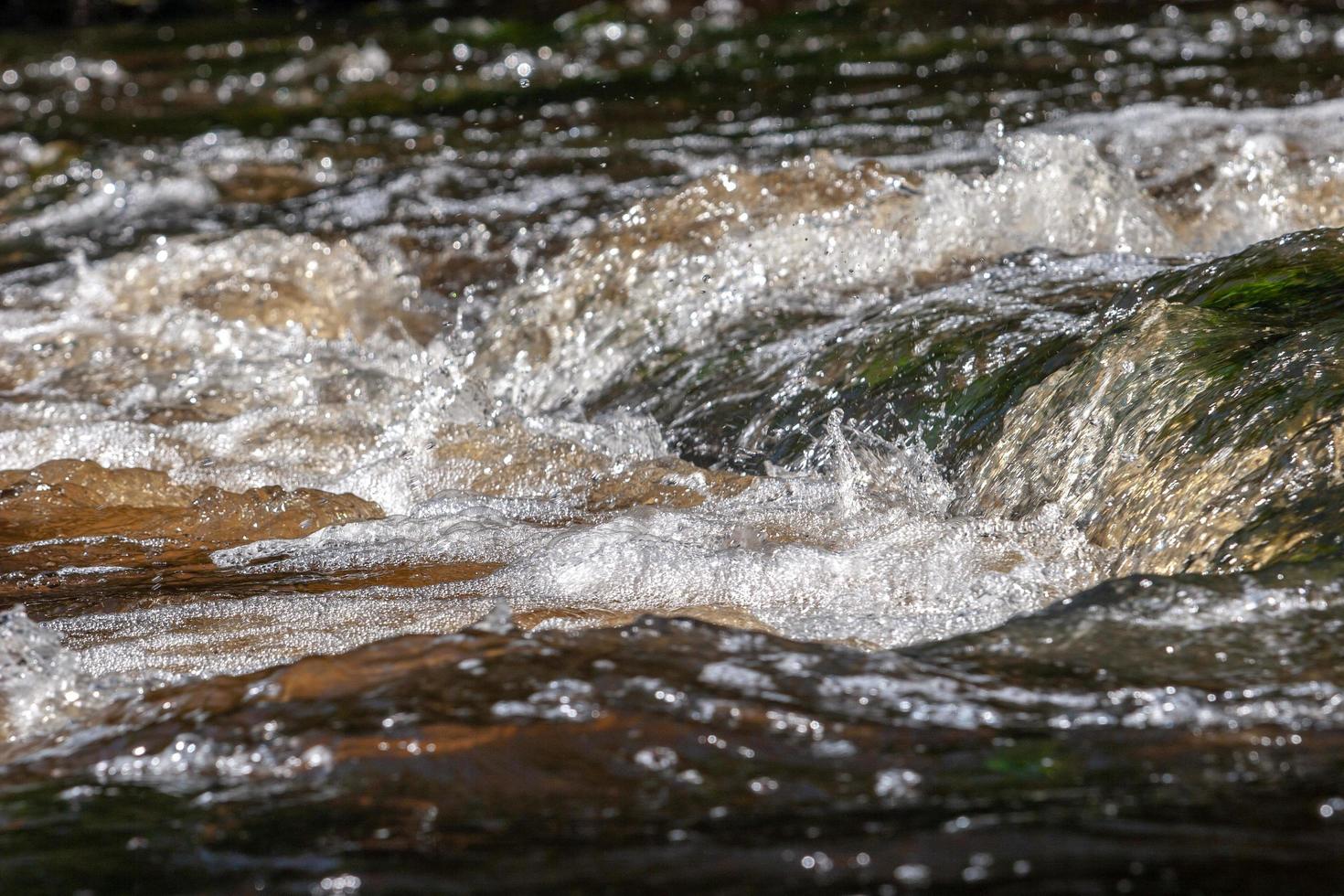 water Aan een rivier- tuimelen met schuim en bubbels. foto