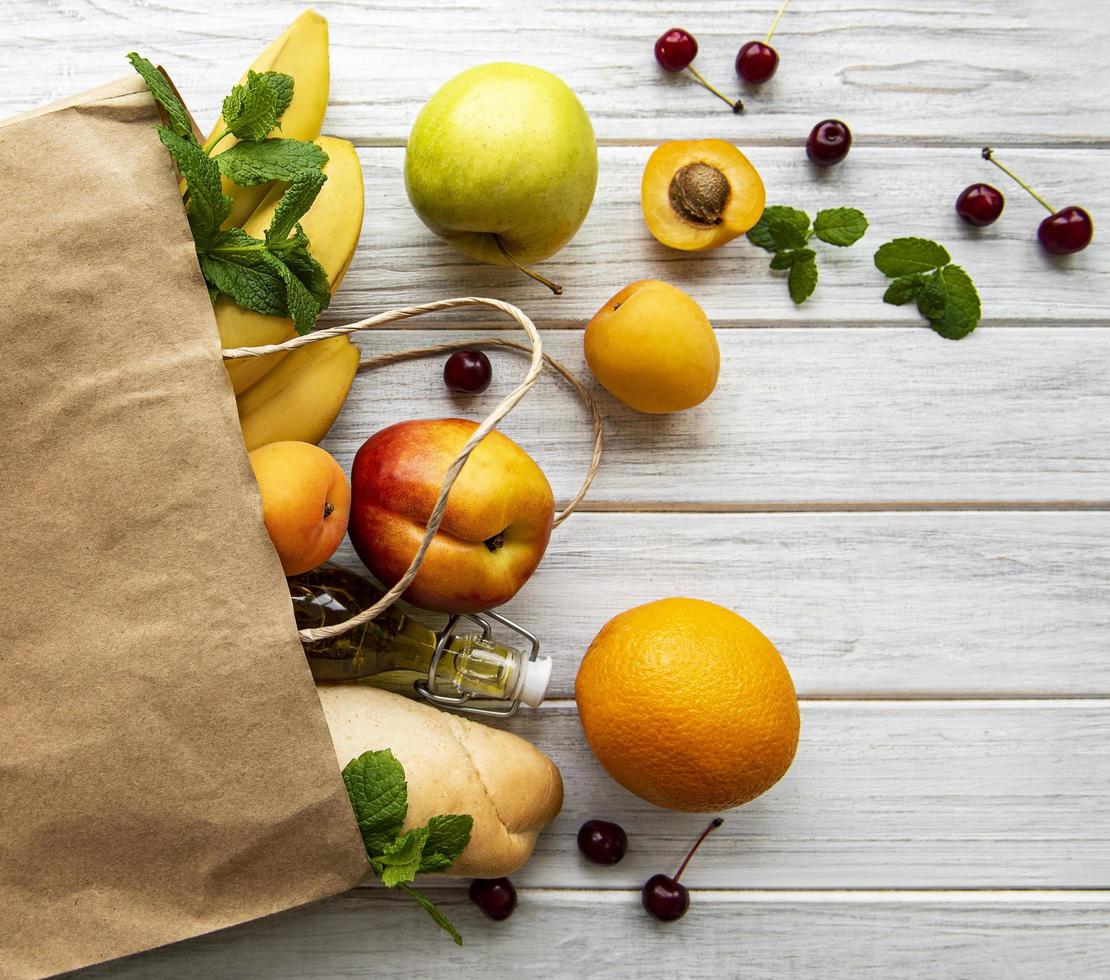 gezond voedsel in een papieren zak, fruit en bessen foto