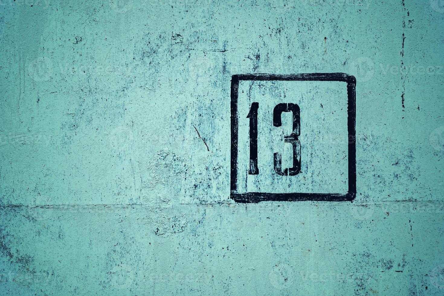 aantal 13 is gesjabloneerd in zwart kader Aan groen beton muur, kopiëren ruimte foto