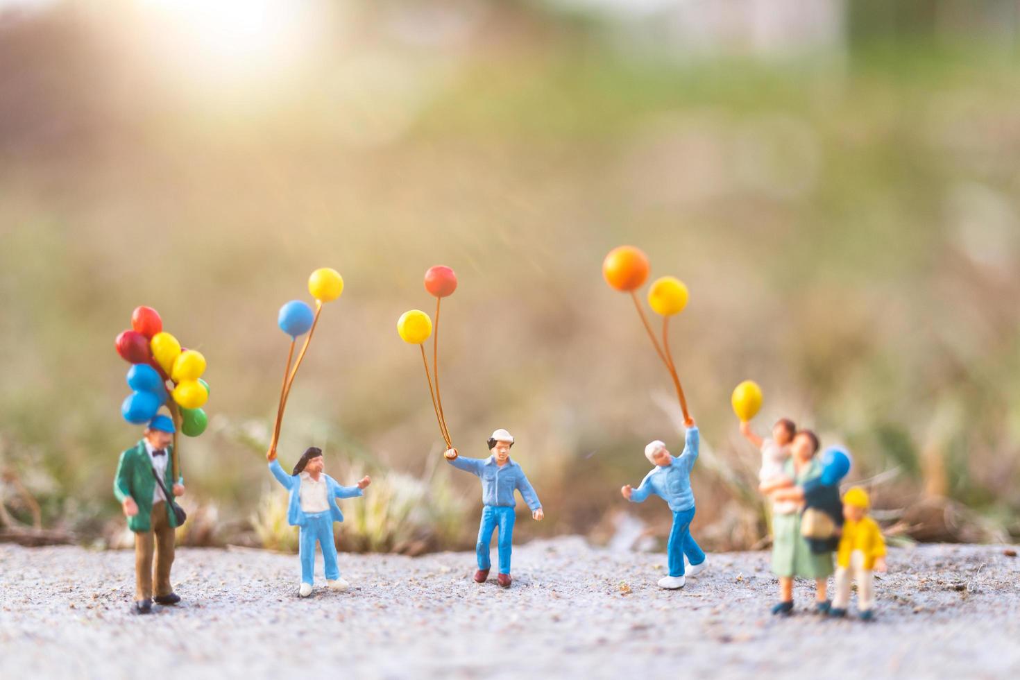 miniatuurfamilie met ballonnen, gelukkige familierelaties en zorgeloos vrijetijdsconcept foto