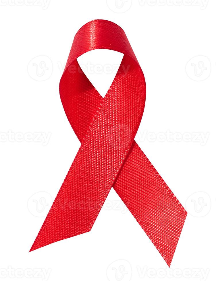 een zijde rood lint in de het formulier van een boog is geïsoleerd Aan een wit achtergrond, een symbool van de strijd tegen AIDS en een teken van solidariteit en steun. foto