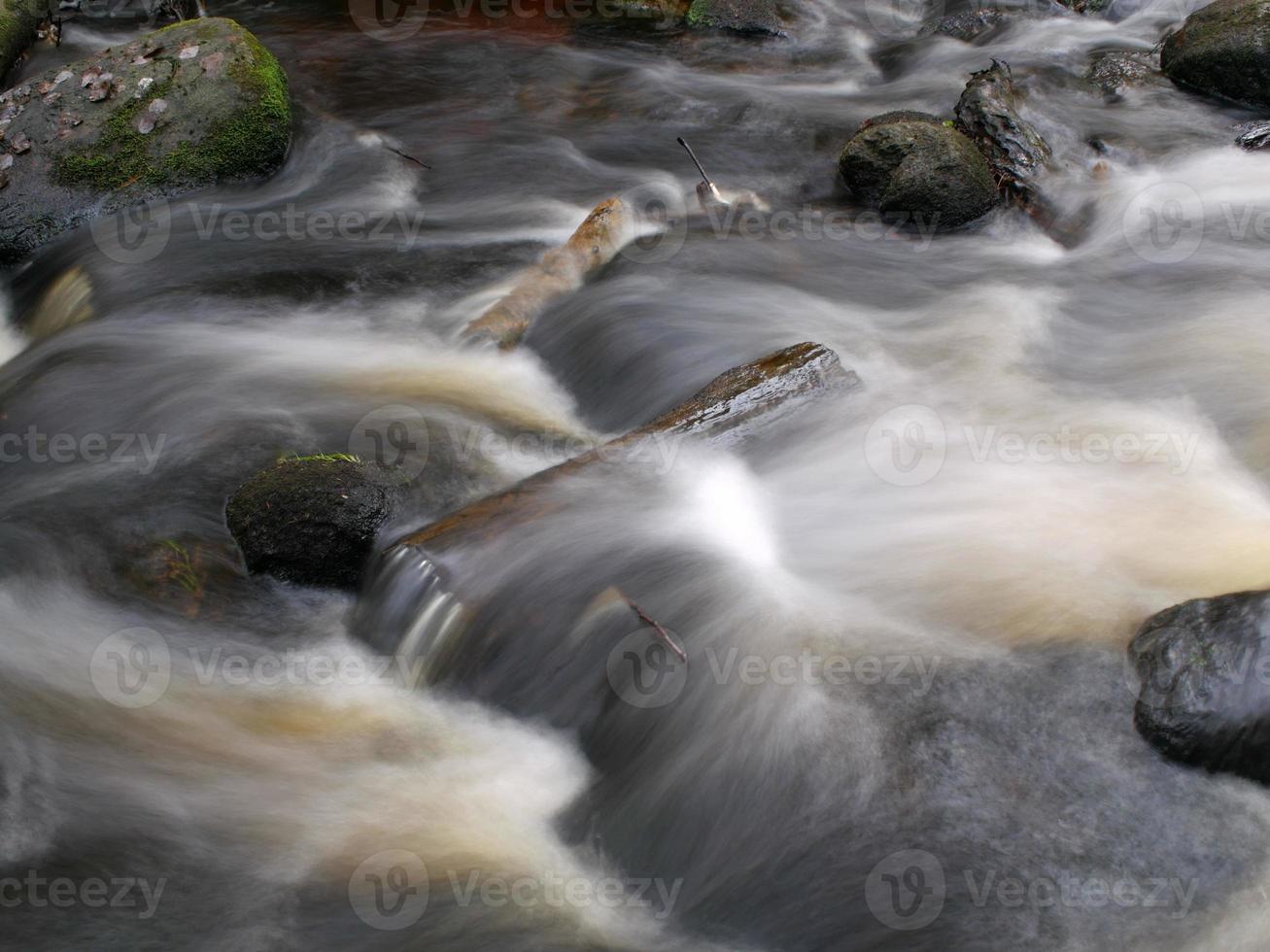 rotsachtig rivier, snel stromen van water lang blootstelling foto