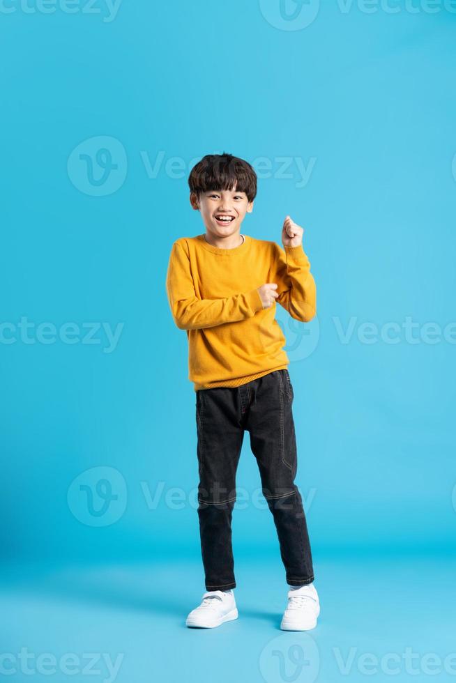 vol lichaam beeld van Aziatisch jongen poseren Aan blauw achtergrond foto