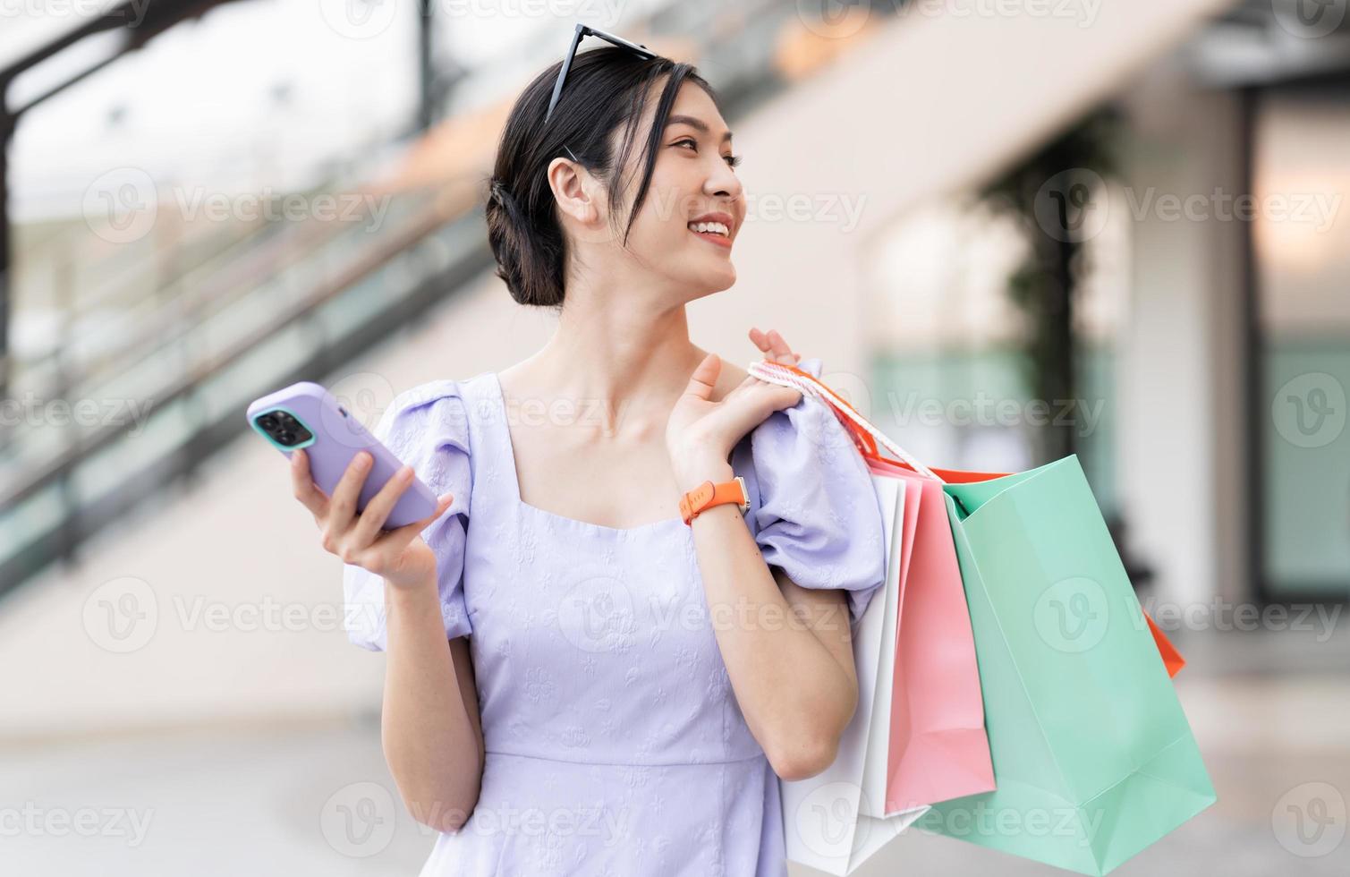 gelukkig Aziatisch vrouw boodschappen doen Bij winkelcentrum foto