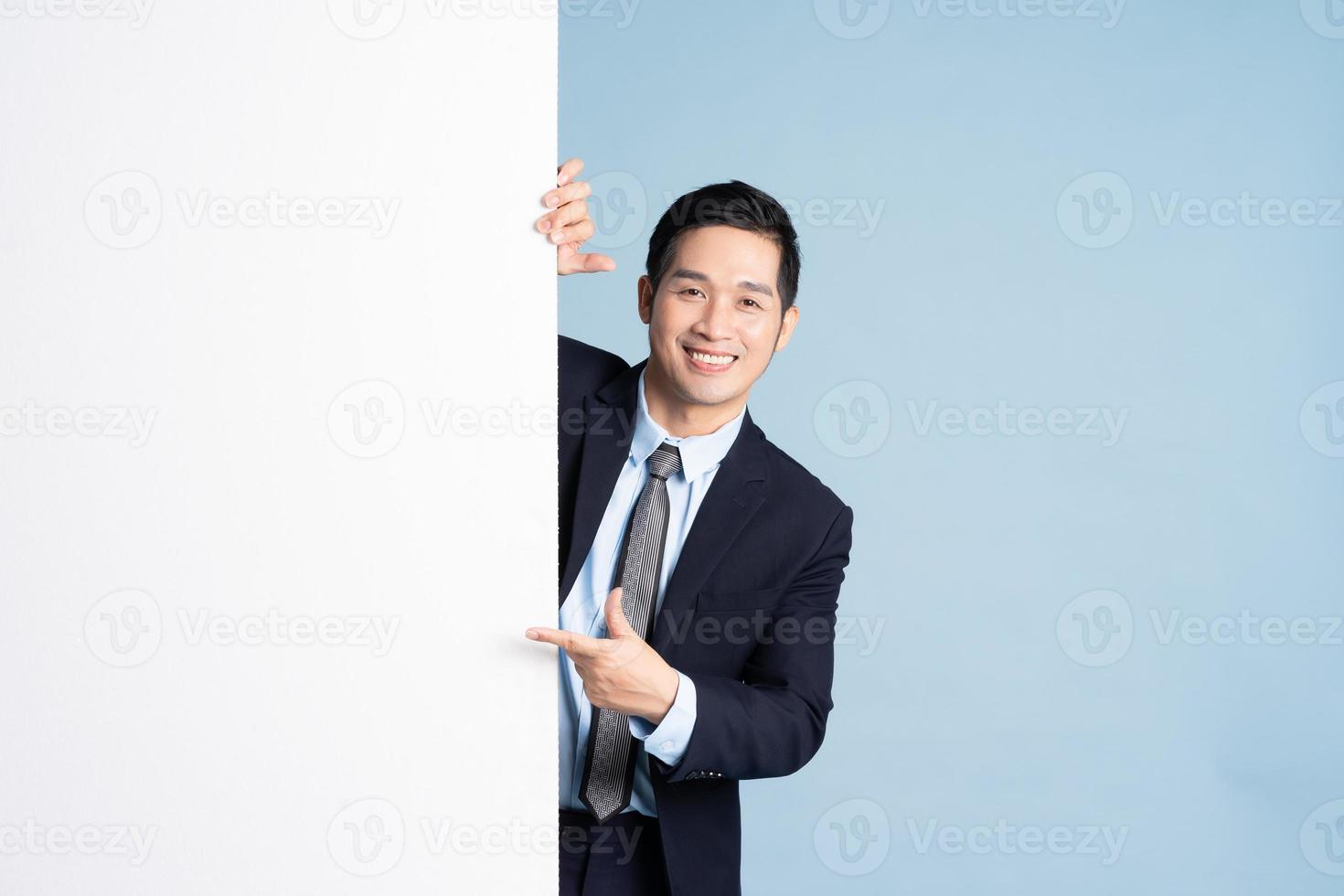 portret van aziatische zakenman die pak op blauwe achtergrond draagt foto