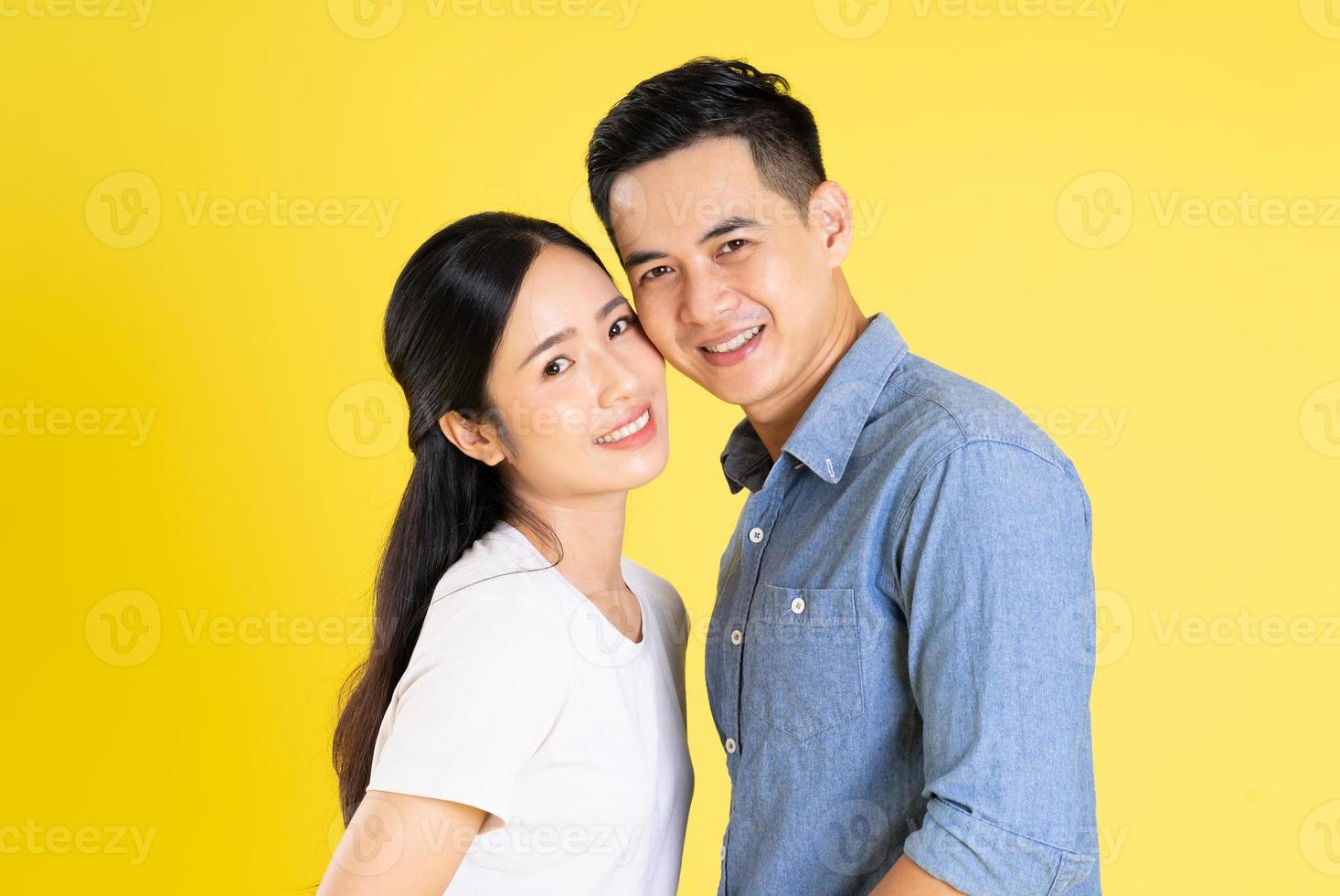 beeld van Aziatisch paar poseren Aan geel achtergrond foto
