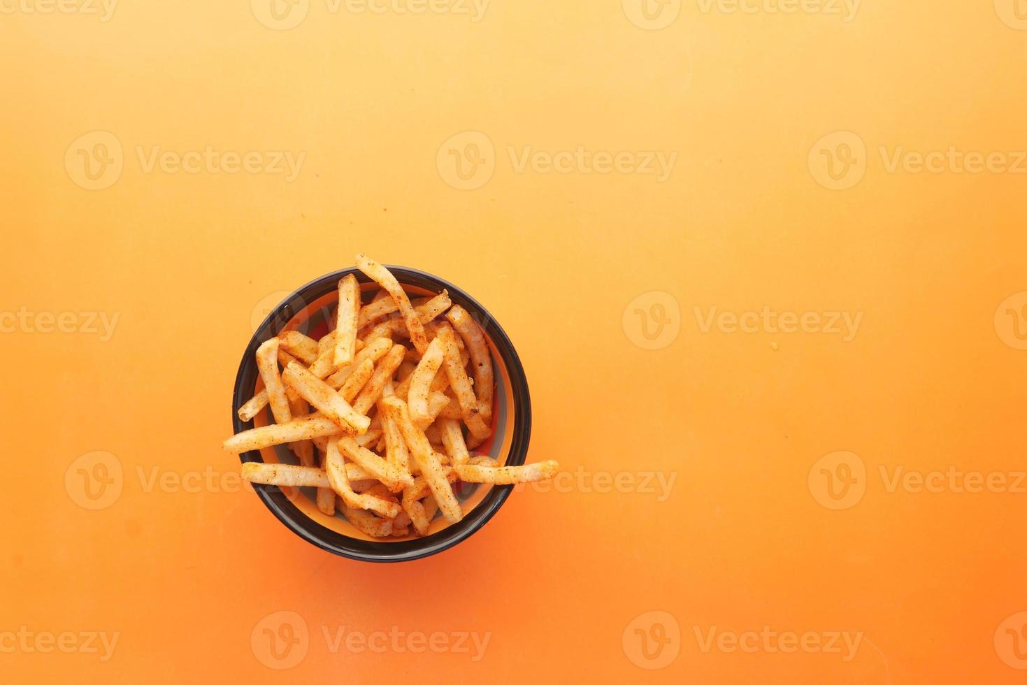 kom met chips op oranje achtergrond foto