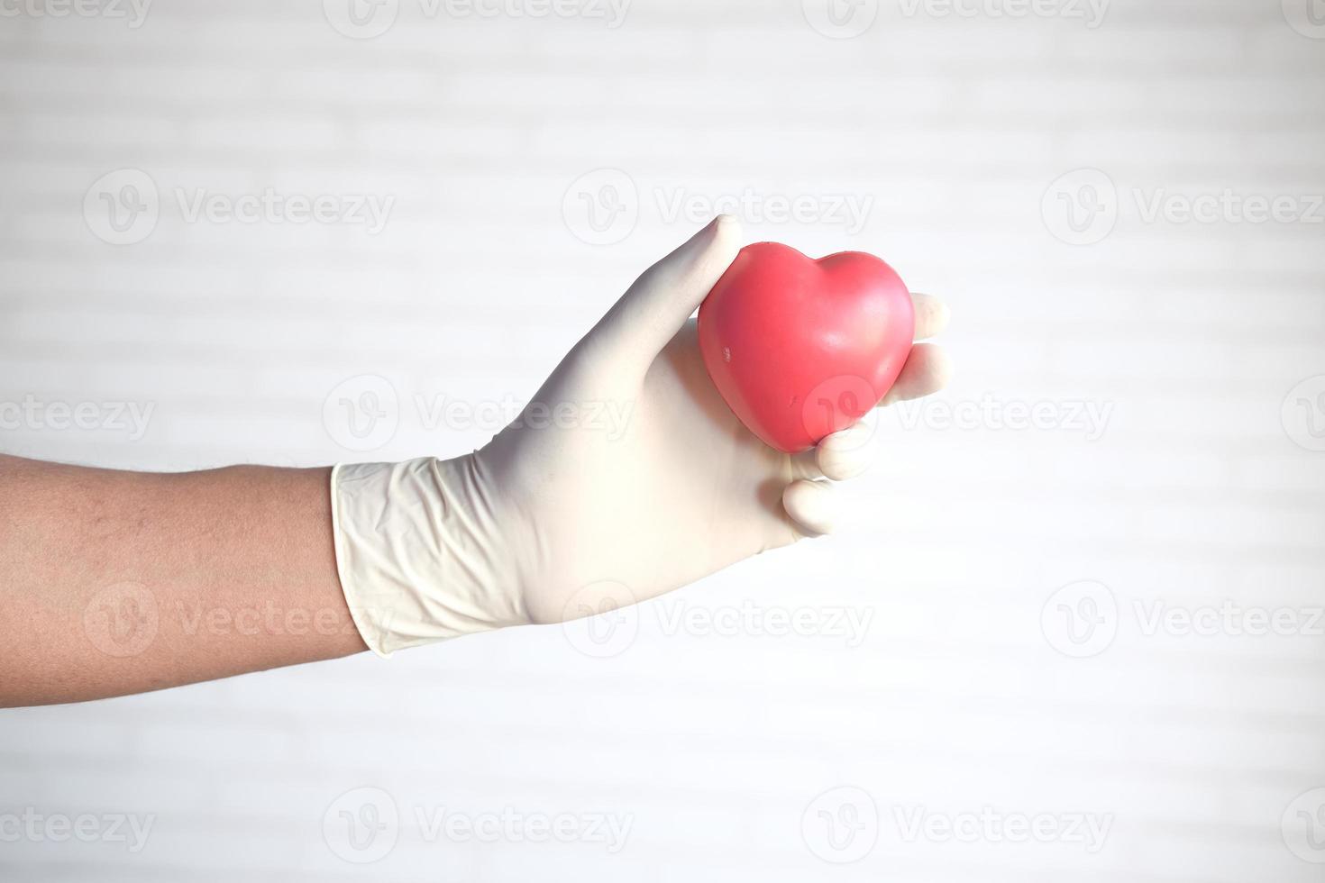 hand met handschoenen met rood hart foto