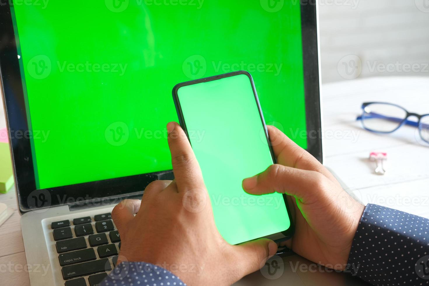 telefoon en computer met groen scherm foto