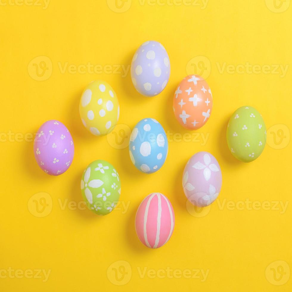 gelukkig Pasen vakantie viering concept. groep van geschilderd kleurrijk eieren decoratie Aan een geel achtergrond. seizoensgebonden religie traditie ontwerp. top visie, vlak leggen, kopiëren ruimte. foto