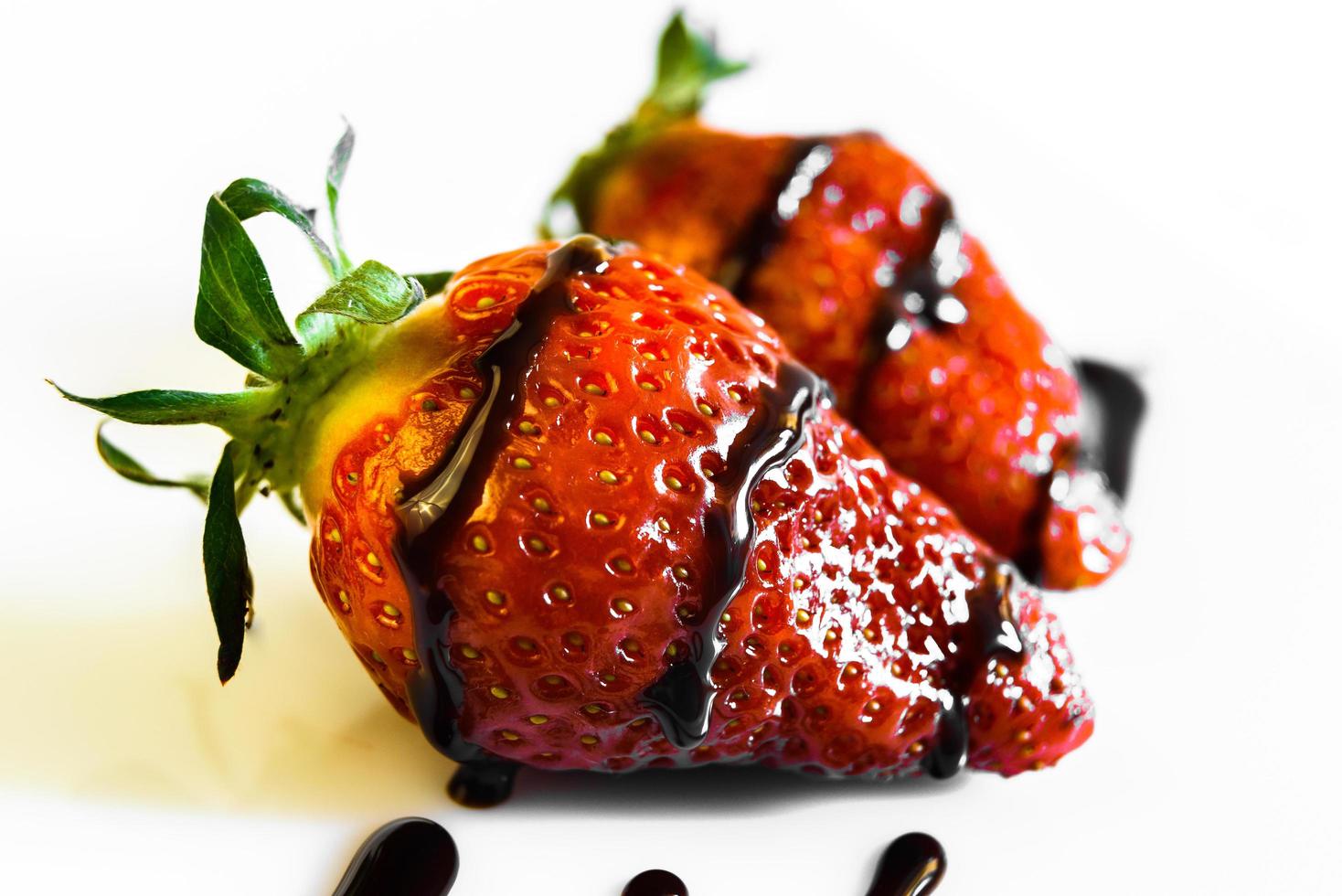 aardbeien met een staart gedrenkt in vloeibare chocolade foto