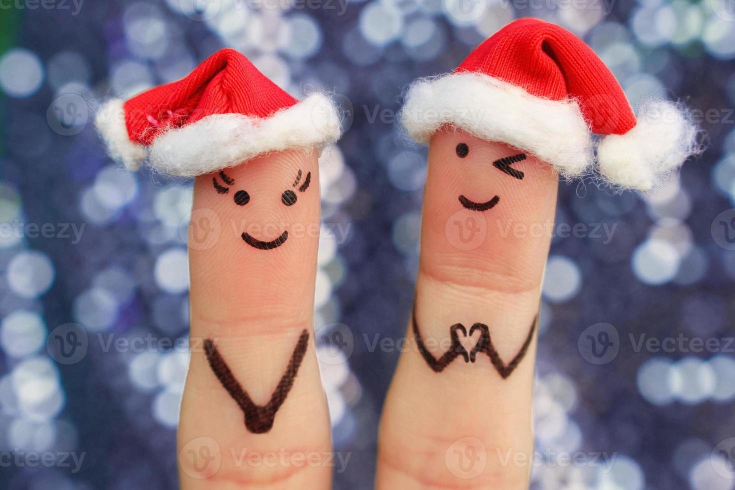 vingers kunst van paar viert kerstmis. concept van Mens en vrouw lachend in nieuw jaar hoeden. vriendje tonen vingers in hart vorm geven aan. afgezwakt afbeelding. foto