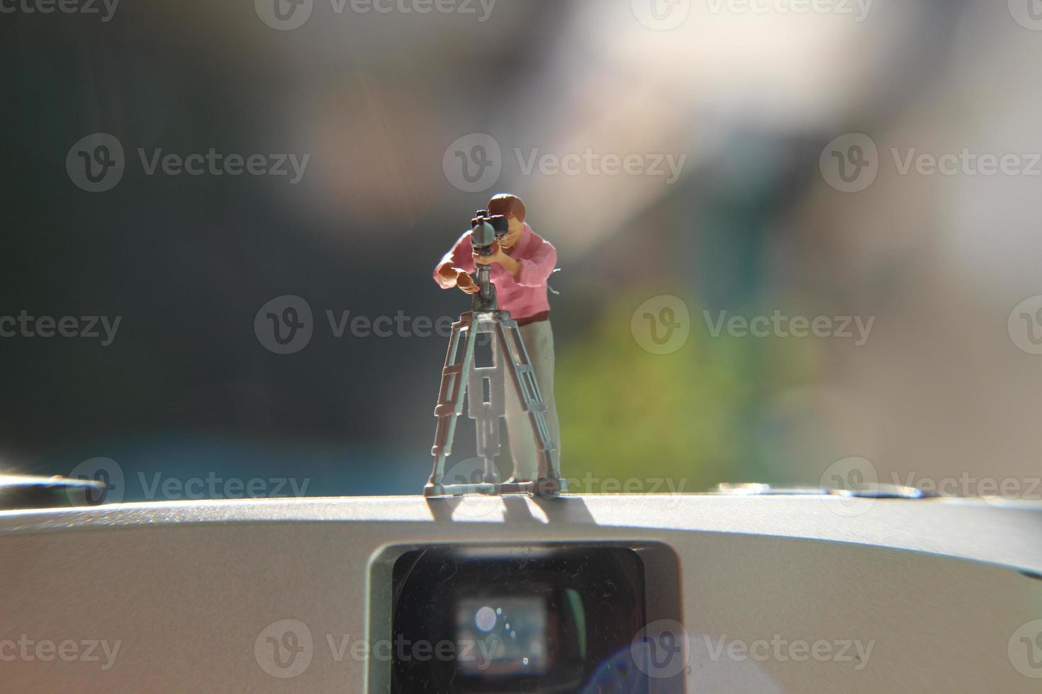 miniatuur figuur van een videograaf opname Aan een analoog camera. foto