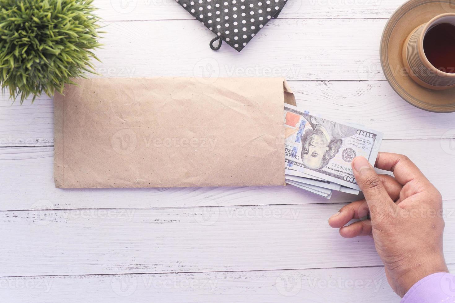 iemands hand contant geld in een envelop steken foto