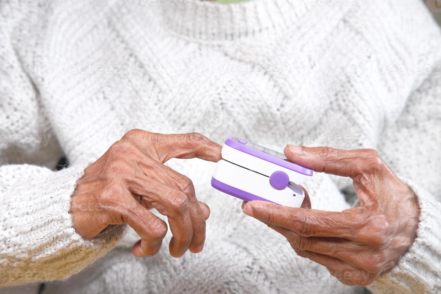 senior vrouw met behulp van pulsoximeter foto